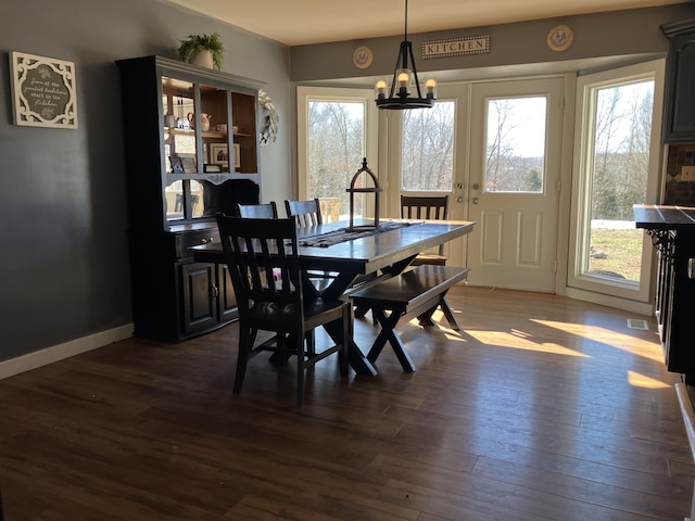 dining area with french doors, dark hardwood / wood-style flooring, and a chandelier