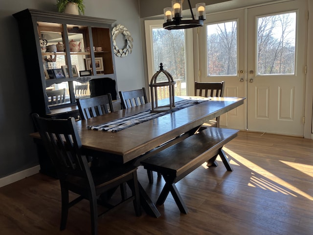 dining area featuring dark hardwood / wood-style flooring, a chandelier, and a healthy amount of sunlight