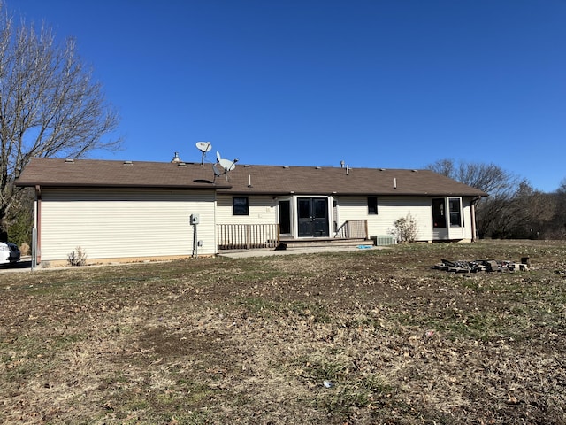 rear view of house featuring a lawn and central AC