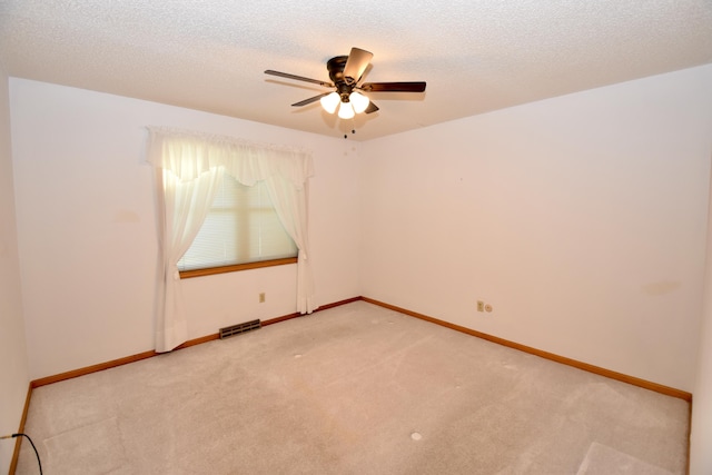 unfurnished room featuring light colored carpet, visible vents, a textured ceiling, and baseboards