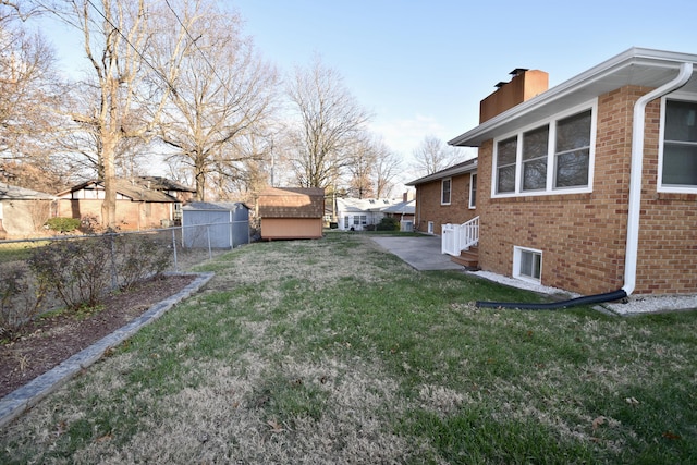 view of yard with an outbuilding, a storage shed, and fence