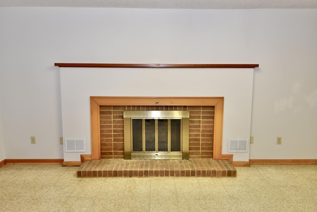 details featuring a brick fireplace, baseboards, visible vents, and a textured ceiling