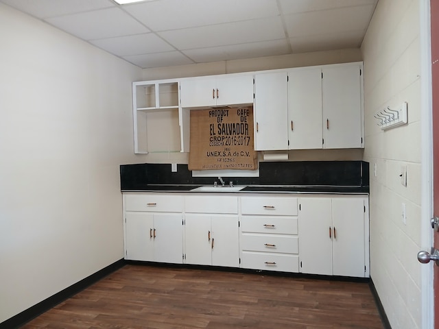 kitchen with a drop ceiling, dark hardwood / wood-style floors, backsplash, white cabinets, and sink