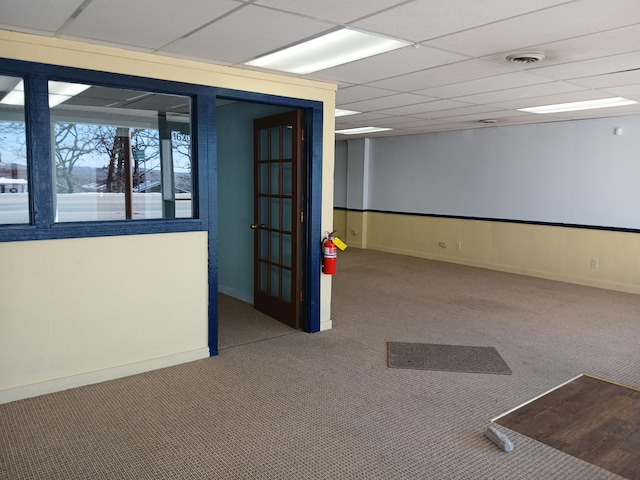 spare room featuring a drop ceiling and carpet