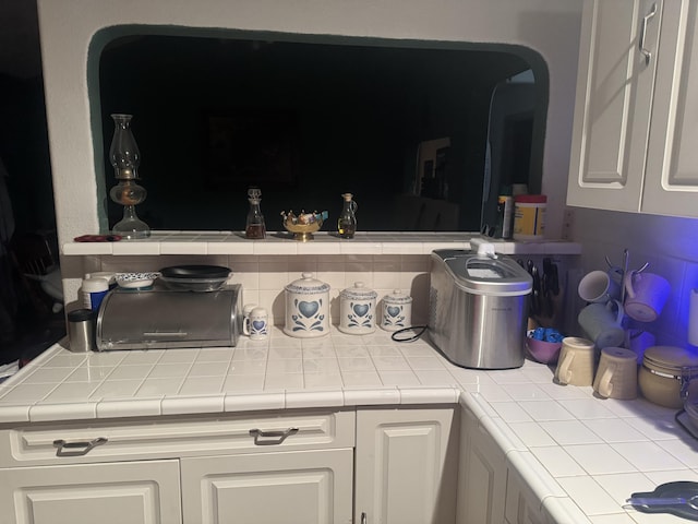 kitchen with tile counters and white cabinets