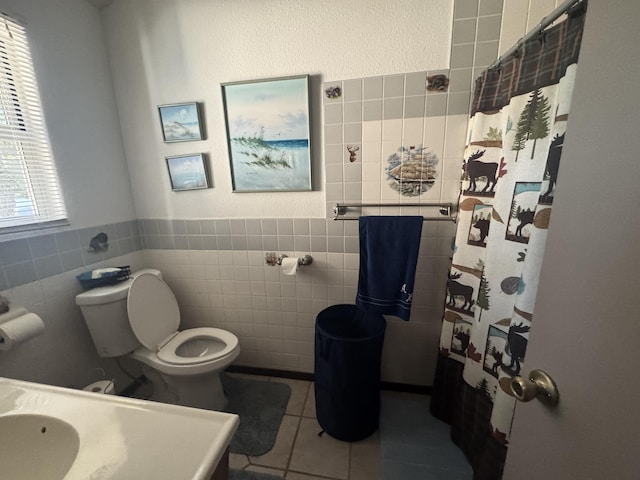 bathroom with toilet, a shower with curtain, tile walls, and tile patterned floors