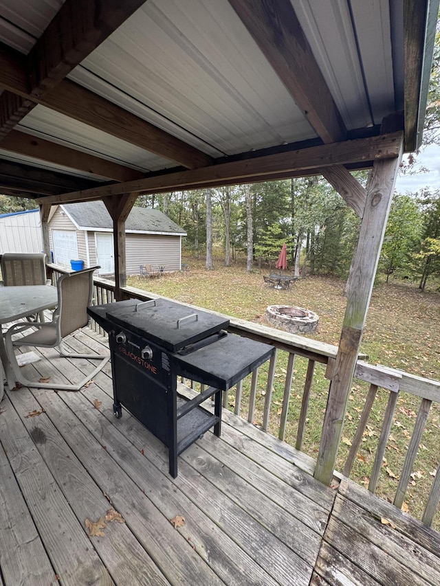 deck with a fire pit and a storage unit