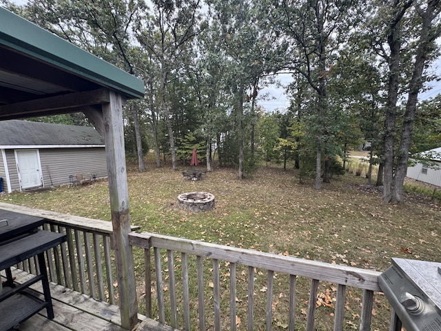 view of yard featuring a deck and an outdoor fire pit