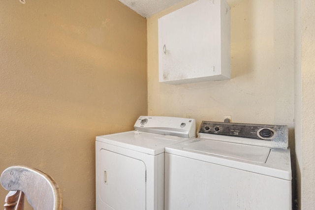 laundry area featuring cabinets, a textured ceiling, and independent washer and dryer