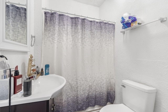 bathroom featuring a textured ceiling, toilet, and a shower with shower curtain