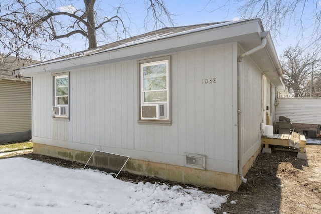 view of snow covered exterior with cooling unit