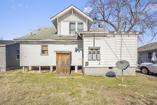 rear view of property featuring a lawn