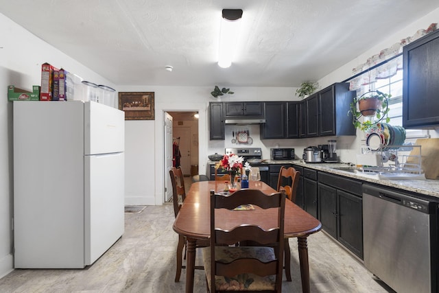 kitchen with light stone countertops, a textured ceiling, appliances with stainless steel finishes, and sink