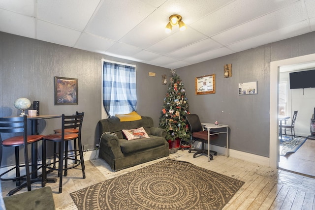 living room with light wood-type flooring and a drop ceiling