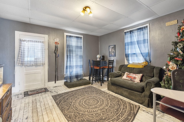 living room featuring a drop ceiling and hardwood / wood-style floors