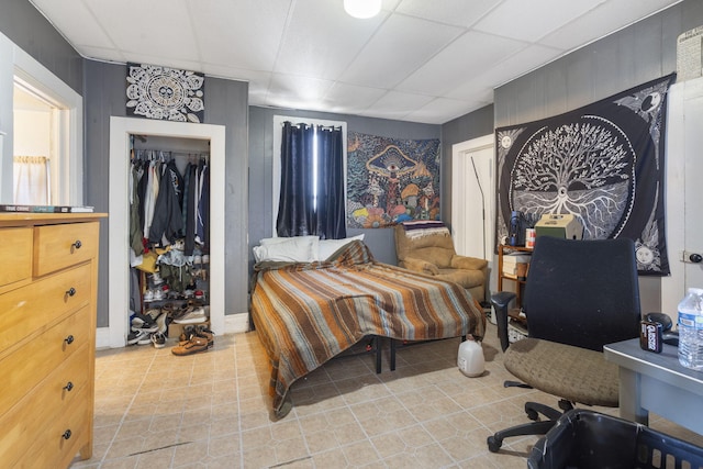 bedroom with a paneled ceiling and a closet