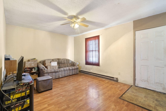 living room with ceiling fan, a baseboard heating unit, a textured ceiling, and hardwood / wood-style flooring