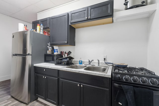 kitchen featuring sink, black appliances, and light wood-type flooring