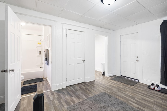 foyer entrance featuring a drop ceiling and dark hardwood / wood-style flooring