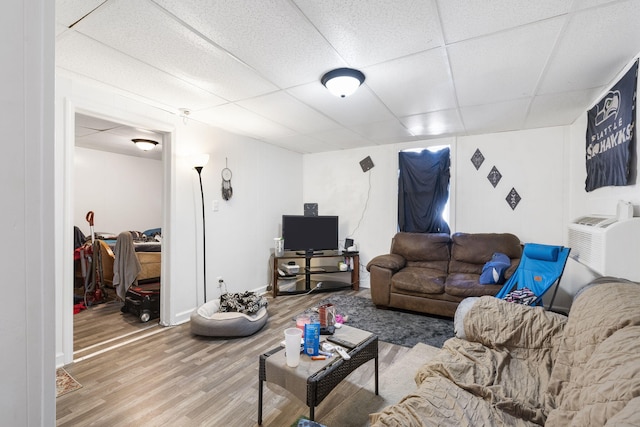 living room featuring hardwood / wood-style flooring and a drop ceiling