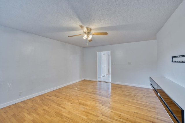 empty room with light wood-type flooring, ceiling fan, and a textured ceiling