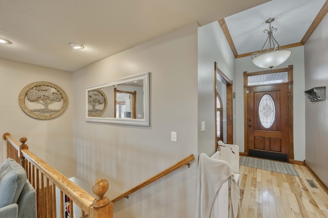 foyer with light hardwood / wood-style floors and ornamental molding