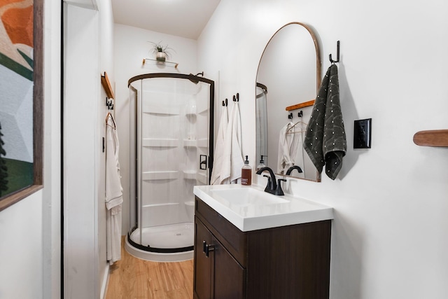 bathroom with hardwood / wood-style floors, an enclosed shower, and vanity