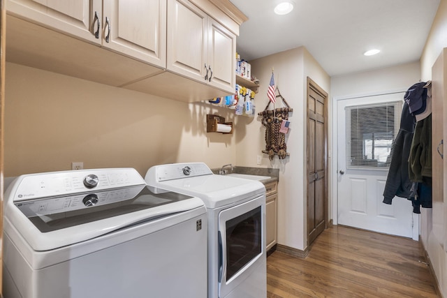 laundry area with washer and dryer, cabinets, hardwood / wood-style floors, and sink