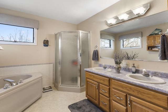 bathroom with tile walls, vanity, and independent shower and bath