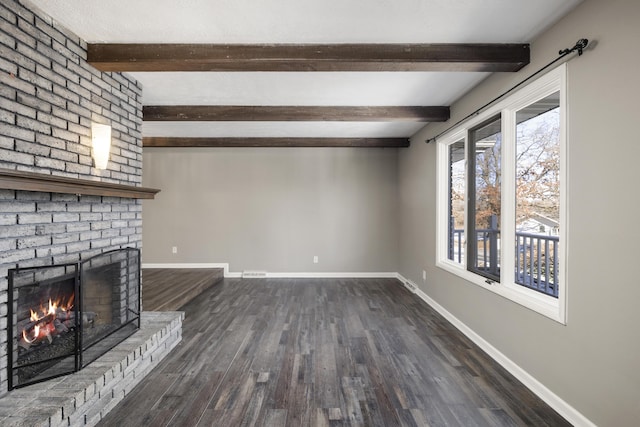 unfurnished living room featuring a brick fireplace, beam ceiling, and dark hardwood / wood-style floors