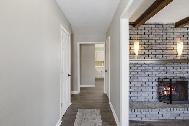 hallway featuring dark hardwood / wood-style flooring and beamed ceiling