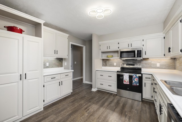 kitchen with white cabinetry, appliances with stainless steel finishes, dark hardwood / wood-style floors, backsplash, and sink