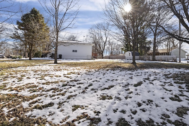 yard covered in snow featuring a storage unit