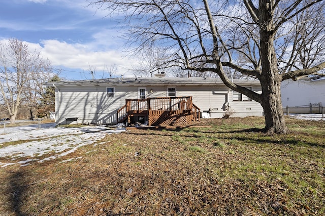 rear view of house with a deck and a lawn