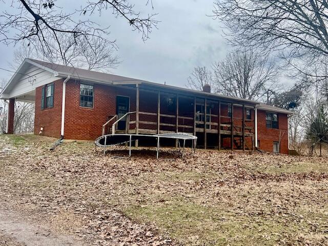 rear view of property with a trampoline