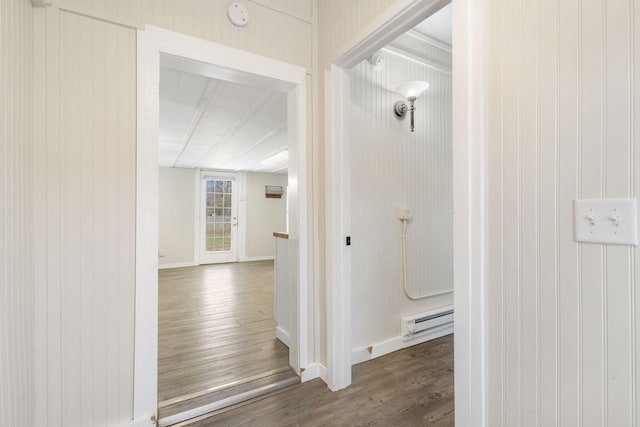 corridor featuring dark wood-type flooring and a baseboard heating unit