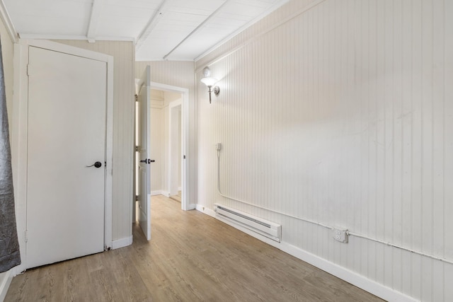 hallway featuring a baseboard heating unit, light hardwood / wood-style floors, and lofted ceiling with beams