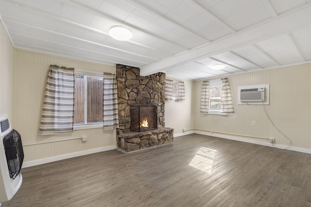 unfurnished living room with wood-type flooring, heating unit, a stone fireplace, and a wall mounted AC