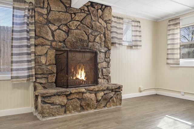 interior details featuring a stone fireplace and hardwood / wood-style flooring