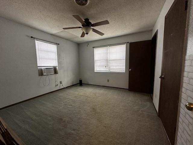 unfurnished room featuring ceiling fan, light colored carpet, a textured ceiling, and cooling unit