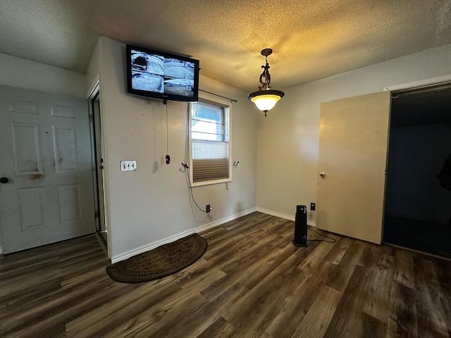 interior space with a textured ceiling and dark hardwood / wood-style floors