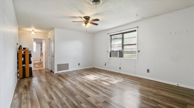 1933 Lynn Dr, West Plains, MO 65775 - empty room featuring wood finished floors, a ceiling fan, baseboards, cooling unit, and a textured ceiling