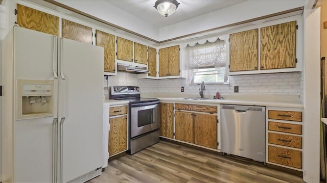 1933 Lynn Dr, West Plains, MO 65775 - kitchen with appliances with stainless steel finishes, a sink, under cabinet range hood, light countertops, and decorative backsplash
