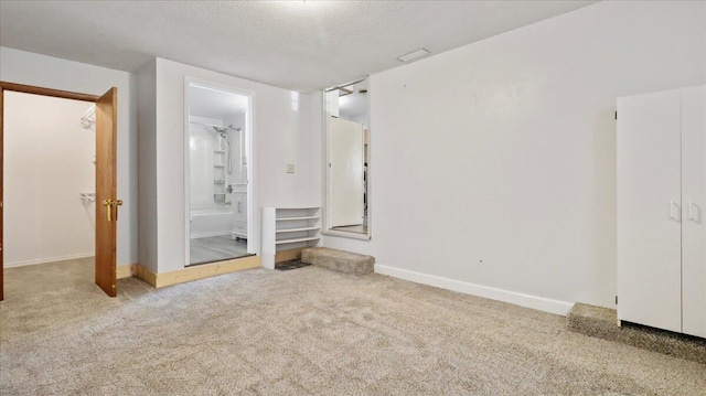 1933 Lynn Dr, West Plains, MO 65775 - unfurnished bedroom featuring carpet, baseboards, ensuite bath, and a textured ceiling