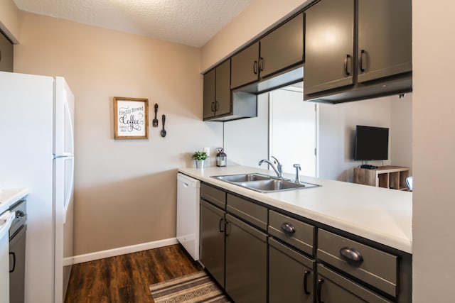 158 Troon Dr Unit 20, Branson, MO 65616 - kitchen with white appliances, dark wood finished floors, a sink, a textured ceiling, and baseboards