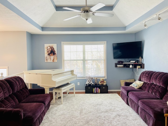 living room featuring ceiling fan, a textured ceiling, a raised ceiling, and track lighting