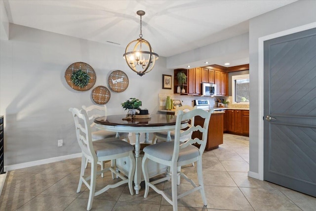 tiled dining room with a notable chandelier