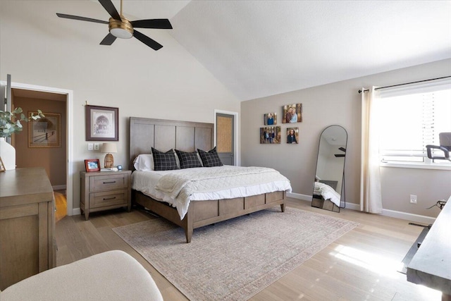 bedroom with ceiling fan, high vaulted ceiling, and light hardwood / wood-style floors