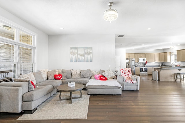 living room featuring dark hardwood / wood-style floors and an inviting chandelier