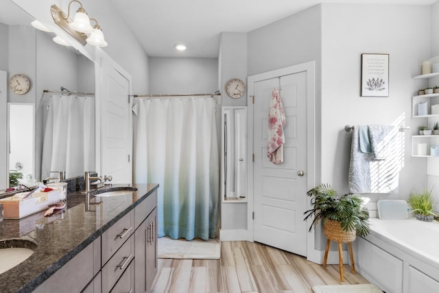 bathroom with plus walk in shower, hardwood / wood-style flooring, and vanity